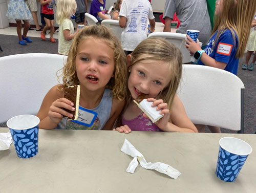two girls enjoy ice cream sandwiches