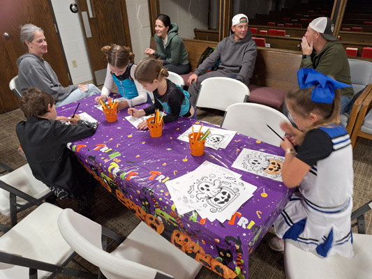 kids coloring at craft table inside